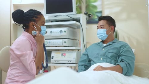 Nurse Listens to Patient's Heart in Hospital Room