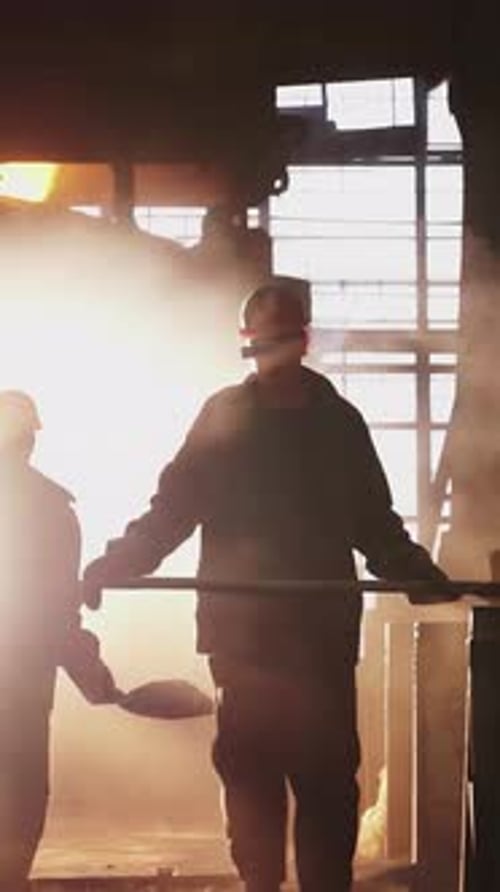 Dedicated Workers in a Bustling Steel Mill Surrounded By the Mesmerizing Glow of Molten Metal Stock