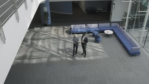 Business people meeting in office lobby using digital tablet