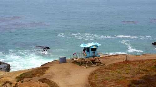 Lifeguard tower stands guard on rocky cliff beach at leo carillo California