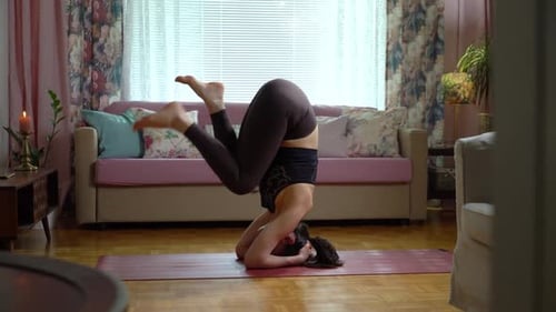 Woman Does Yoga Headstand Exercise at Home