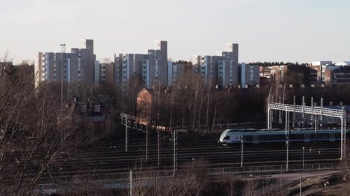 Korrigieren Sie die Drohnenaufnahme des Zuges oder der U-Bahn, die von rechts nach links fährt, mit Bäumen auf beiden Seiten der Schiene