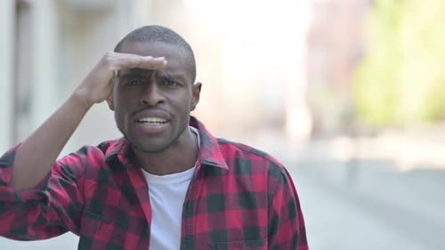 Young Adult Man Looking and Shielding Eyes