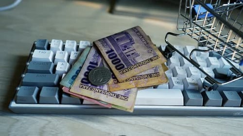 Miniature Shopping Cart with Currency on Computer Keyboard
