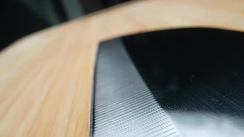 Close Up Metal Cleaver Resting on Wood Cutting Board