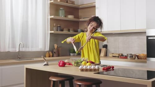 Woman Prepares Salad While Listening to Music