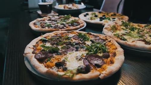 Lots of Pizzas on the Table in a Pizzeria