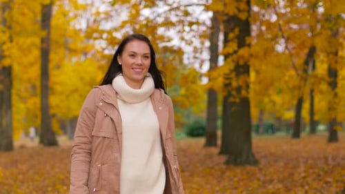 Season And People Concept - Happy Young Woman Walking In Autumn Park