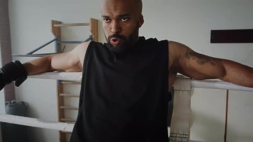 Muscular Man Relaxing in Boxing Ring