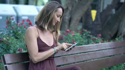 Elegant Woman Browsing Tablet in City