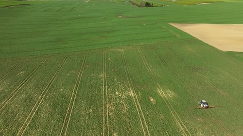 Tractor Spread Slurry On Pasture Farm Field in Spring season during sunny day. Farmers theme. Aerial