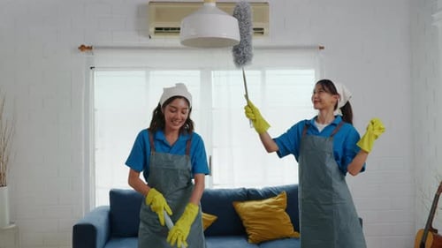Das Reinigungsservice-Team Zwei Frauen in Handschuhen und Uniformen reinigen das staubige Wohnzimmer fleißig mit einem Wischmopp