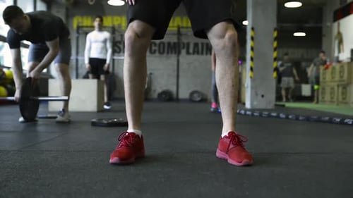 Young People in Crossfit Gym Exercising, Man Lifting Kettlebell Active