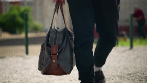Casual Man with Bag Walking in Park Morning Quiet City Park Walk with Man Carrying Leather Bag Early
