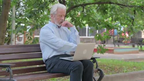 Man Using Laptop on Park Bench Outdoors