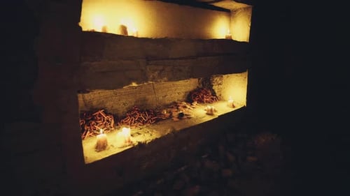 Mysterious Cave Interior with Flickering Candles and Rusty Chains