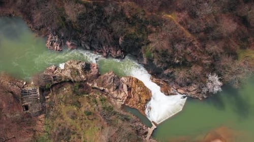 Aerial drone footage of beautiful lake and waterfall in a forest during spring 1
