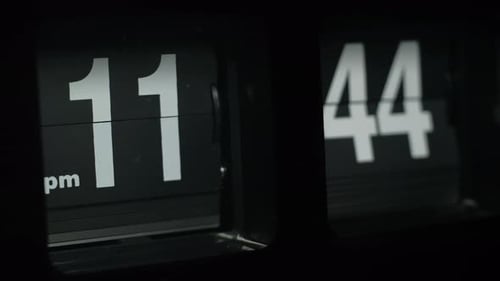 Flipping clock on a black background, in the style of time-lapse video.
