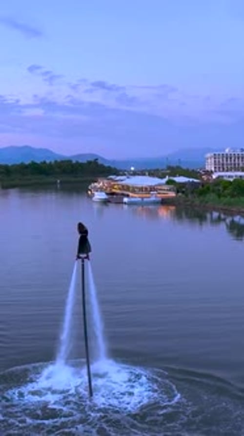 Vidéo verticale Excitation et sensations aériennes en flyboard avec une fille survolant la rivière Belek