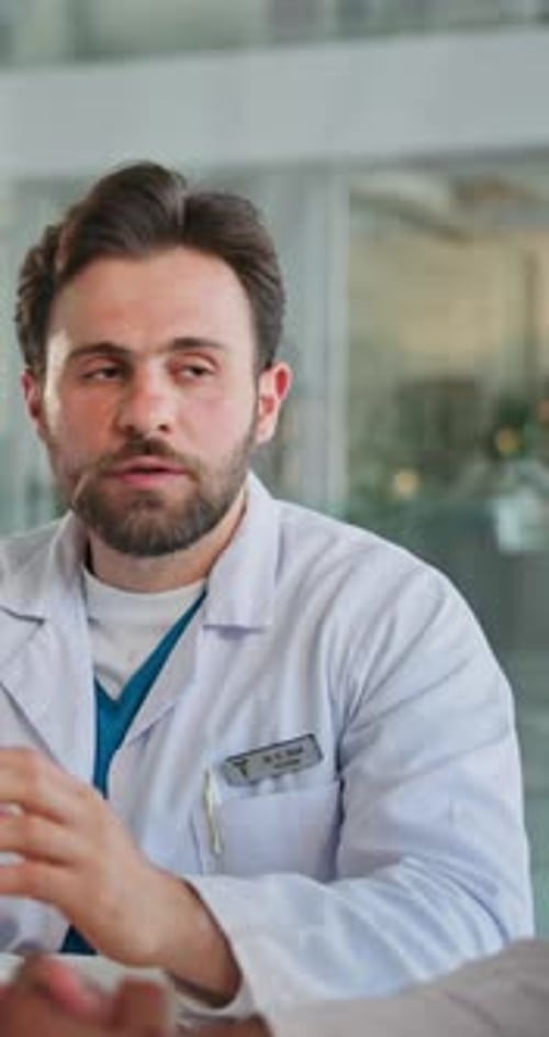 Man in Lab Coat Talking With Colleague in Office