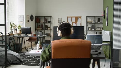 Black Male Developer Stretching while Running Vibe Coding Agent on Computer
