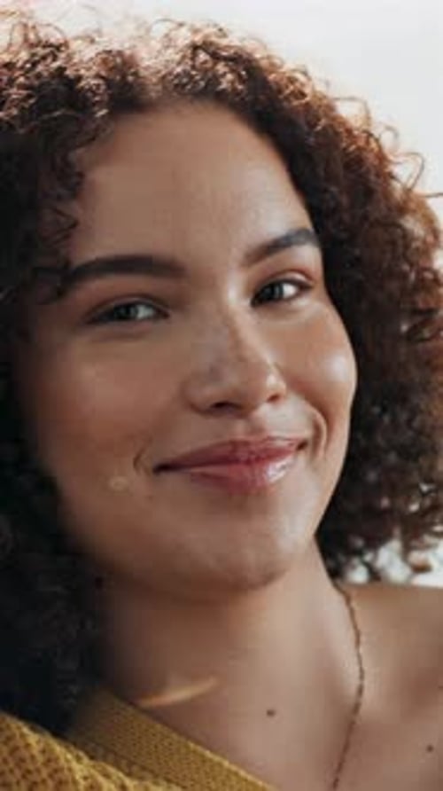 Close Up of Smiling Young Woman with Curly Hair