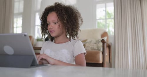 African American girl using digital tablet for homework