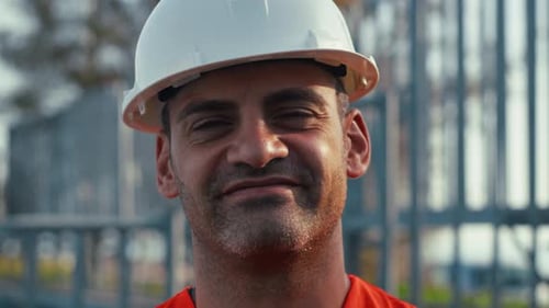 Mann mit weißem Helm lächelt in die Kamera
