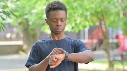 Casual African Man Using Smart watch in a Park