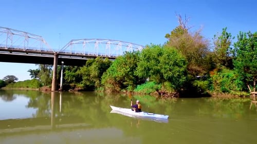 Kayaker paddles down river through beautiful Texas countryside landscape