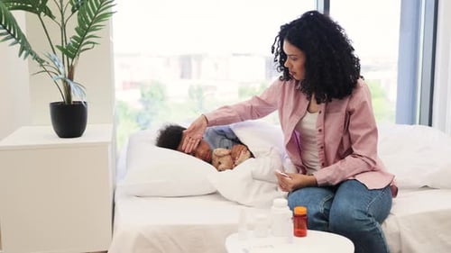 Woman Checking Temperature of Sick Child in Bed