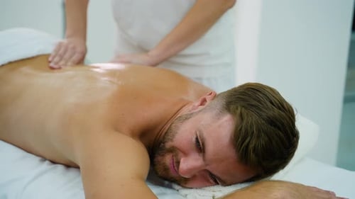 Man Enjoying Relaxing Back Massage at Spa