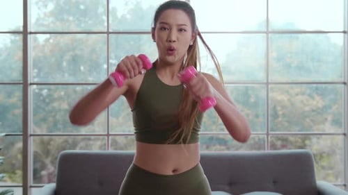 Woman Does Boxing Punches with Dumbbells at Home