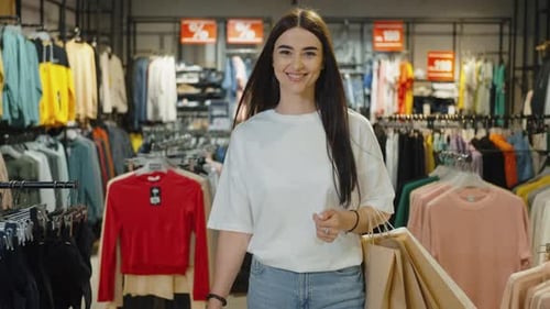 Femmes souriantes marchant avec des sacs à provisions dans un centre commercial