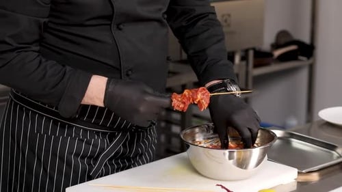 Chef Prepares Meat Skewers in Commercial Kitchen