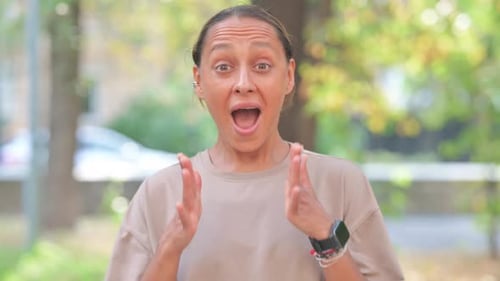 Woman Reacts with Excitement in City Park