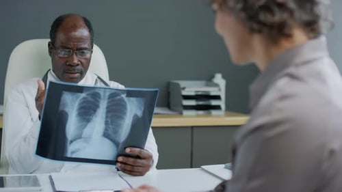 Doctor Explains X-Ray to Patient in Medical Office