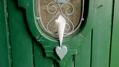 paper cone resting on rustic green heart door