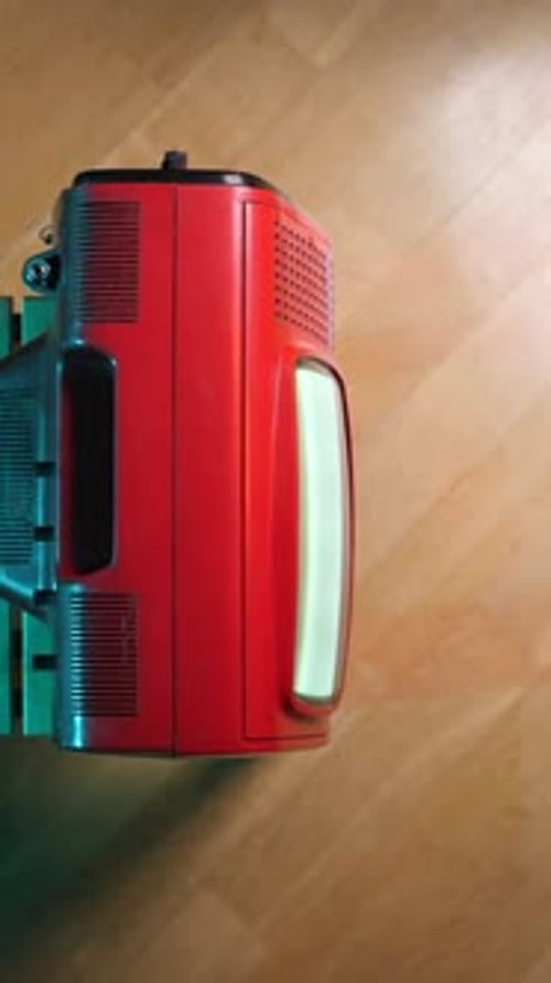 Vertical Video Top View Red Vintage Portable Television on Wooden Stool Displaying Static Screen