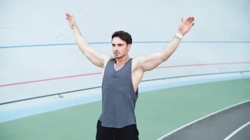 Man Stretching Arms on Running Track Before Workout