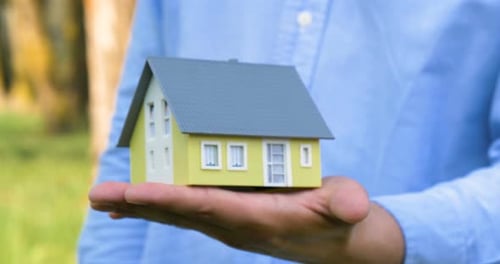 Small Model House Held in Open Palm