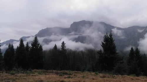 Left to right panning shot of a mountain landscape with mist.