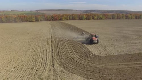 Big red combine working on the field cultivating and applying nitrogen ASP