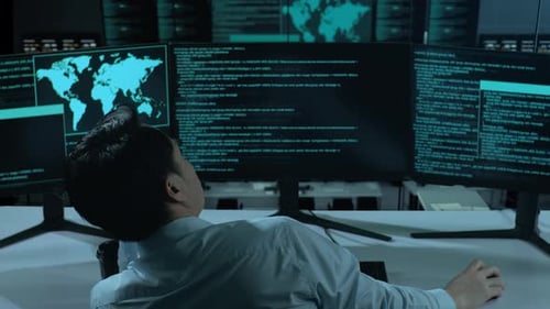 Back View Of Bored Asian Man Write Code With Multiple Computer Screens In office