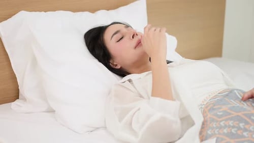 Asian woman sleeping in bedroom at home