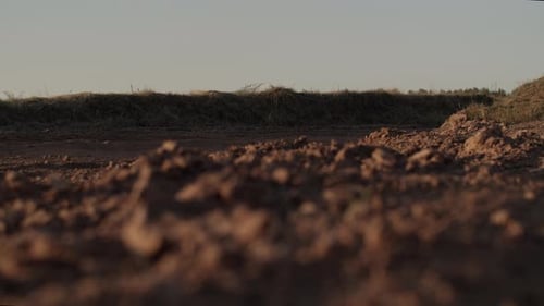 Dirt Bike Rider Speeds Along Dusty Road