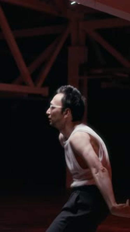 Vertical of Flexible Young Man Dancing in Red-lit Space