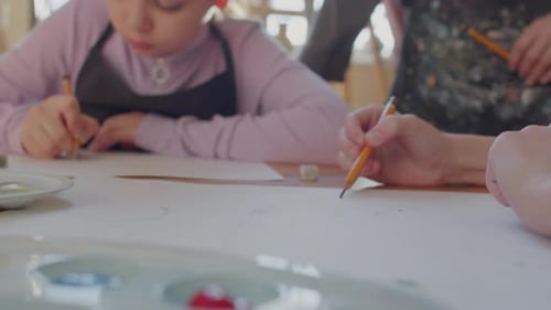 People Drawing Together with Pencils in Studio