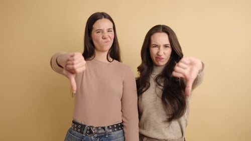Two Women Giving Thumbs Down Gesture Together