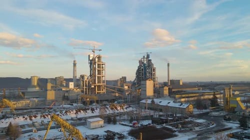 Aerial view of cement plant with high factory structure and tower crane at industrial production